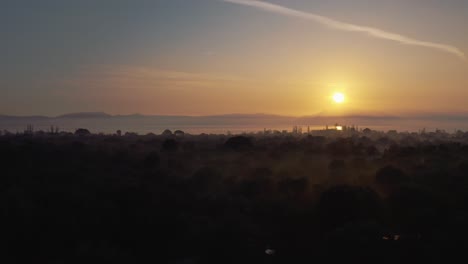 aerial drone flight over downtown mitilini revealing sunrise at sea with ferry to athens, lesvos, greece
