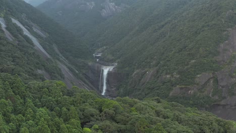 Senpiro-Falls-in-Yakushima-Japan,-Wide-Aerial-Pan-of-Tall-Waterfall