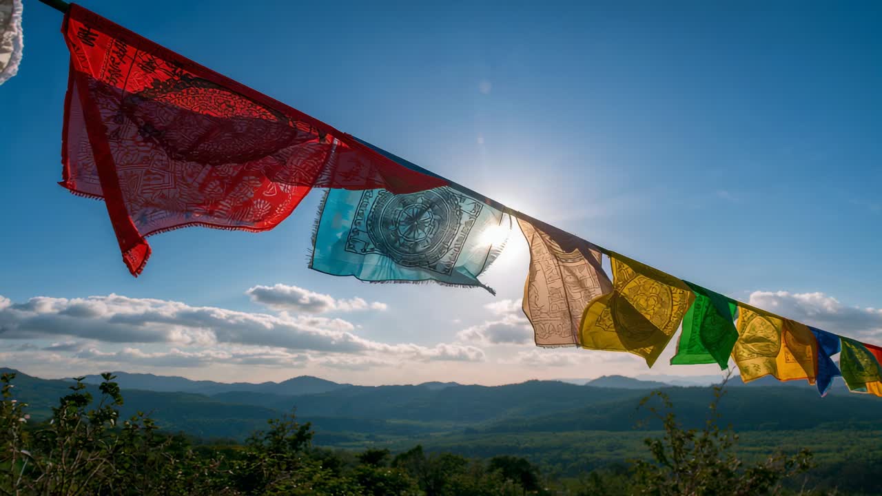 Billowing prayer flags fluttering on rope at hilltop as gusts lift them, sun backlighting blue flag