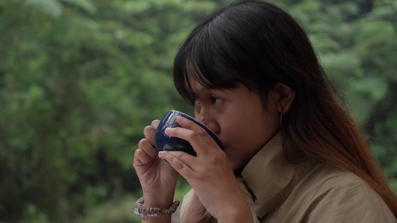 Indonesian girl enjoying a cup of coffee on a cold day