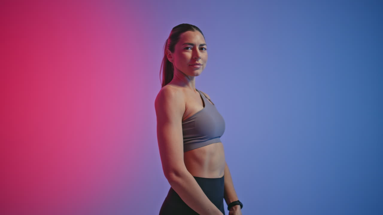 Closeup fitness woman jumping in neon sport club. Sport lady using skipping rope