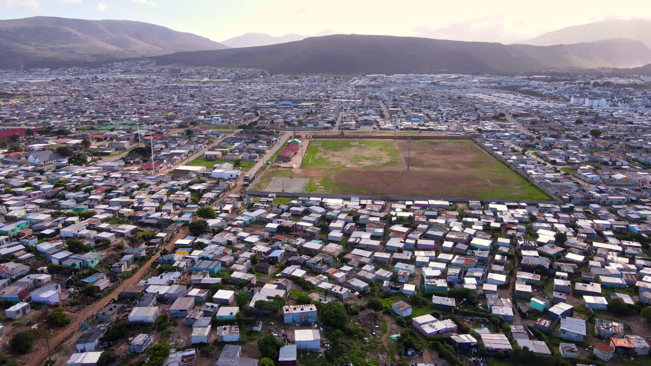 Wide aerial descent with view over vast squatter camp township in South Africa