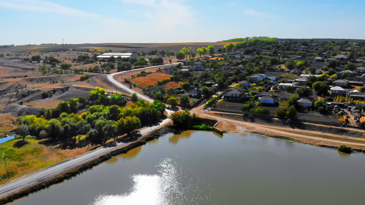 Maramonovca village located on the coast of a lake. Aerial drone view with fields on the background in Moldova. Panoramic shot