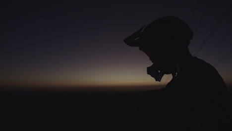 Piloto-De-Motocross-Y-Bicicleta-De-Montaña-Con-Casco-Integral-Al-Atardecer