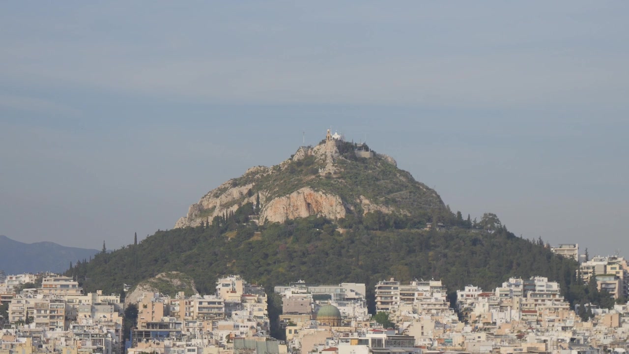 Collina del Licabetto sopra i fitti tetti e i condomini di Atene in Grecia.