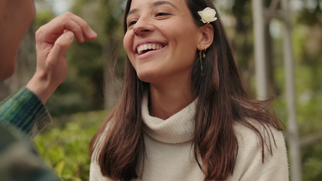 Close up young man putting flower behind his girlfriend's ear