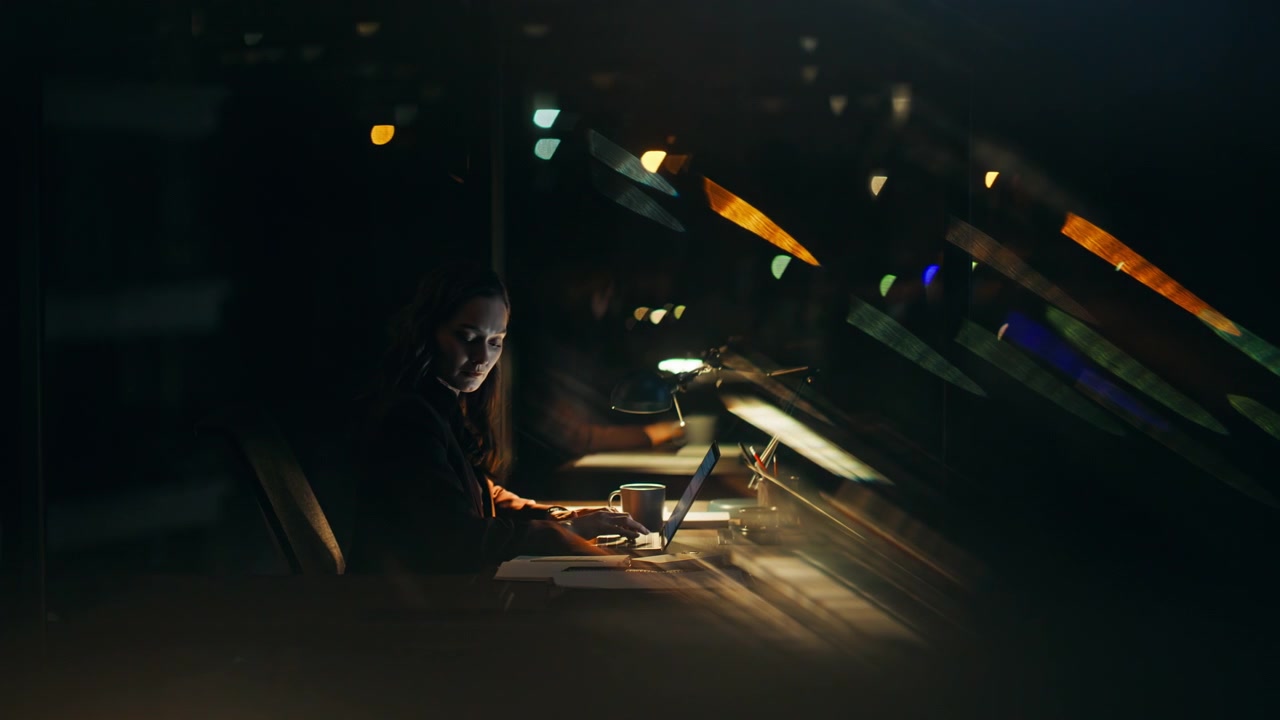 Lavoratore notturno che digita al computer, seduto alla scrivania dell'ufficio. Dipendente che scrive