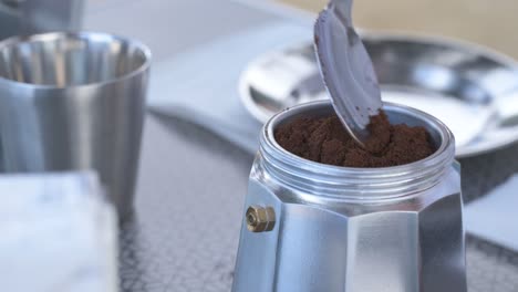 brewing coffee with moka pot at a campsite on a sunny day