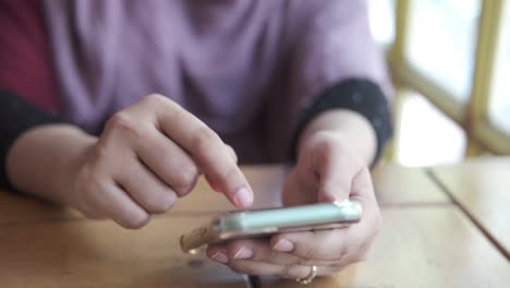 mujer usando un teléfono inteligente en un café