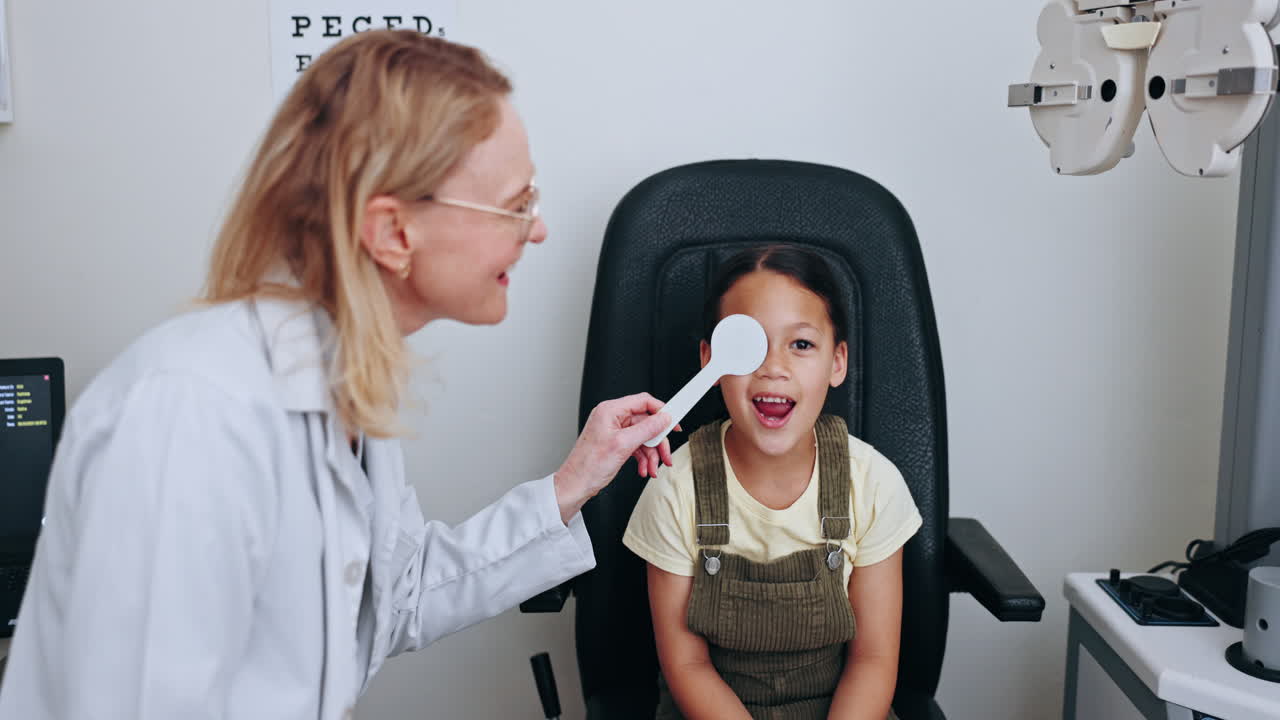 Eye test, patient and optometrist cover child