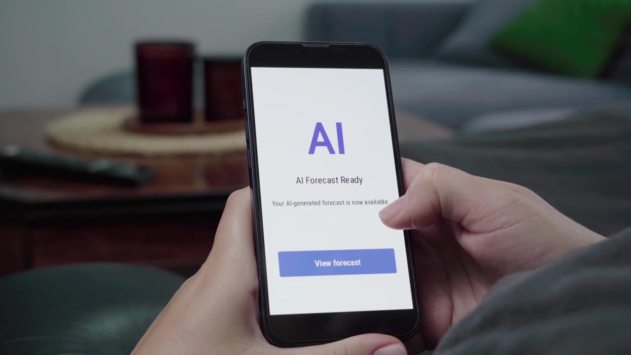 Una persona tiene in mano uno smartphone che mostra una schermata "AI Forecast Ready" con una call-to-action per visualizzare la previsione generata