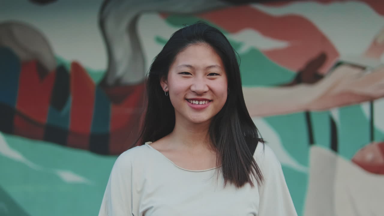 Portrait of a Smiling Woman in Front of a Mural