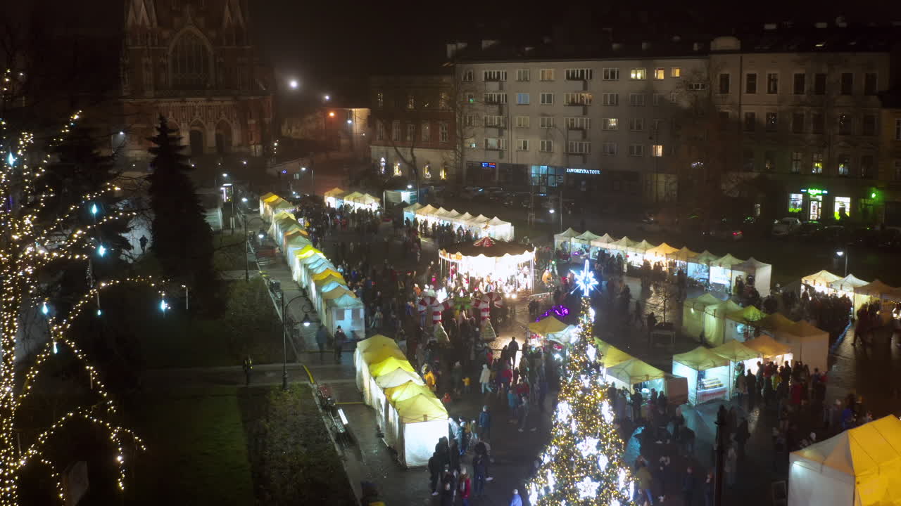 Vista drone di bancarelle natalizie e giostra in Piazza Podgórski con San