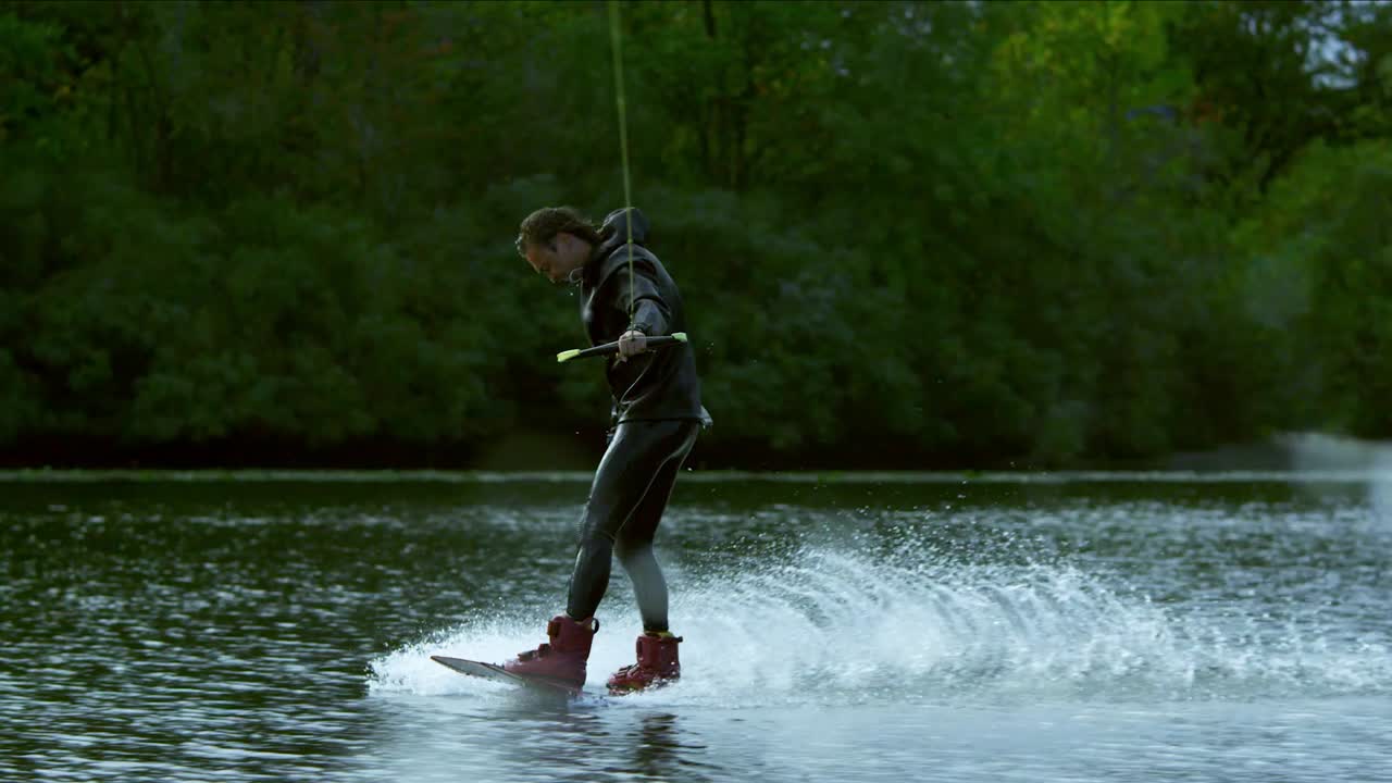 Wake boarding on river. Male rider enjoy wakeboarding. Extreme lifestyle