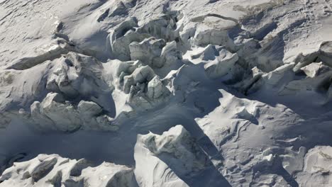 Vista-Superior-Aérea:-Picos-Helados-En-Los-Alpes-Con-Nieve-Iluminada-Por-El-Sol