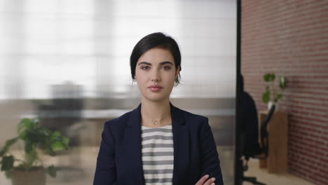 retrato de una hermosa joven mujer de negocios mirando seriamente a la cámara brazos cruzados ejecutiva femenina enfocada en el espacio de trabajo de la oficina