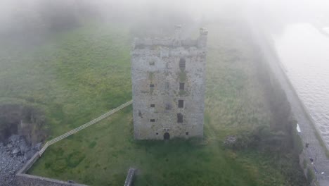 Drone-dropping-shot-of-Carrigaholt-castle-on-the-Shannon-river