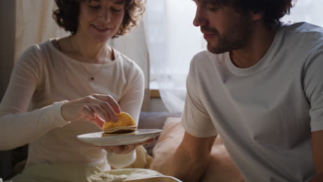 couple enjoying breakfast in bed