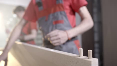 carpenter using a hammer to drive a wooden dowel