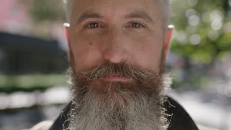 close up portrait of mature sophisticated bearded man staring contemplative looking at camera