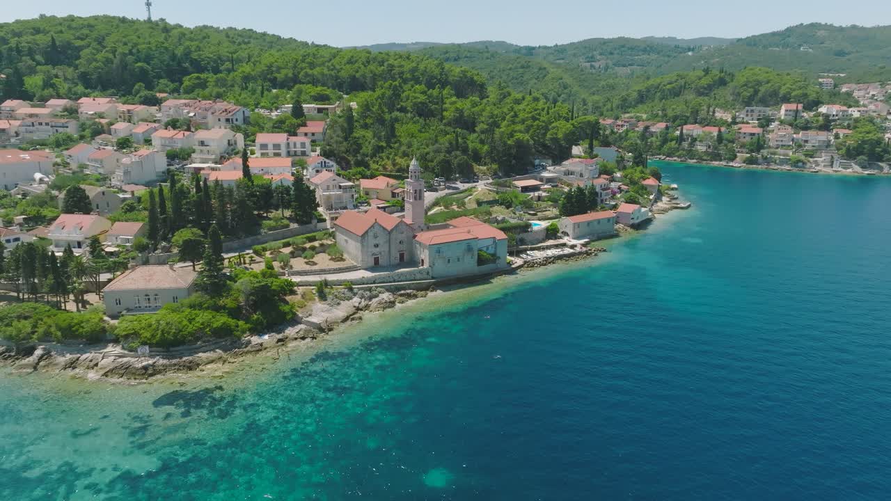Úchvatná přírodní scenérie města na ostrově Korčula a tyrkysové vody Jaderského moře za slunečného dne v Chorvatsku.