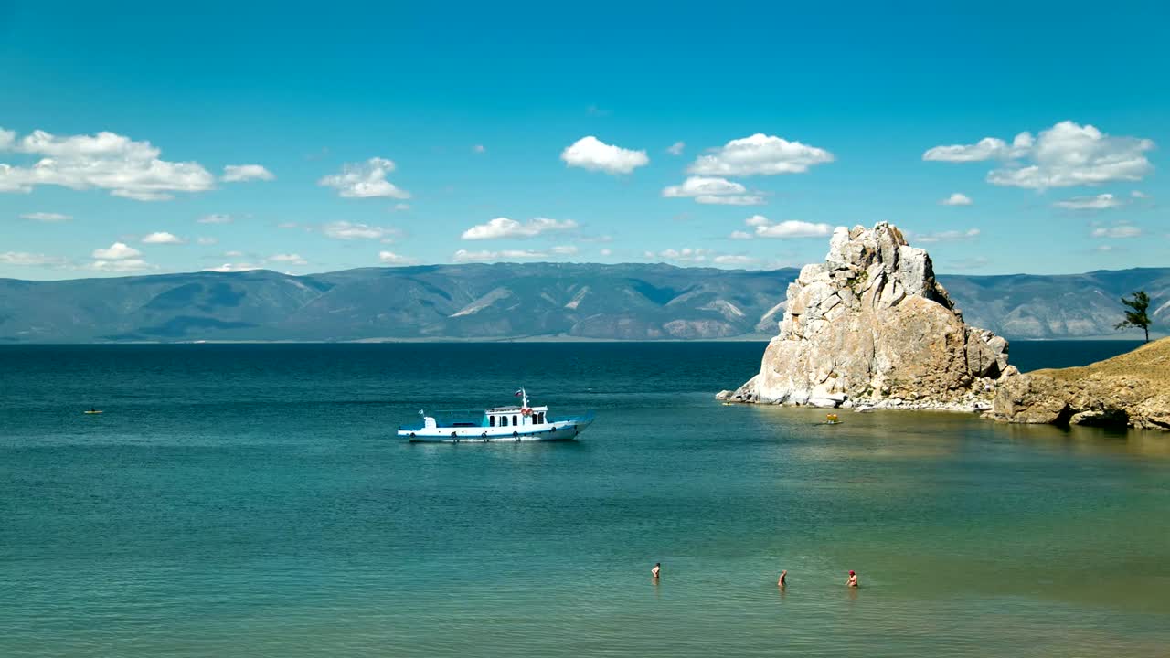 barcos y turistas nadando en la bahía. nubes que cambian rápidamente.