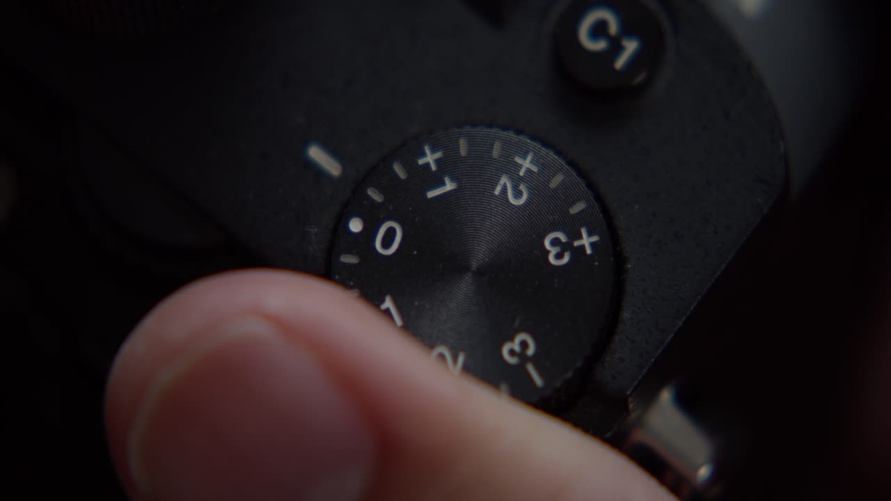 A finger adjusts the wheel of a camera, close shot