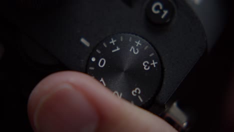 a finger adjusts the wheel of a camera, close shot