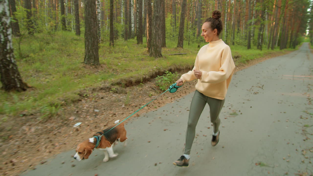 mujer corriendo con perro en el bosque