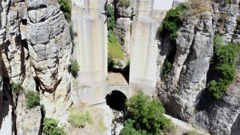 Drone-shot-backing-out-from-under-the-bridge-in-Ronda,-Spain