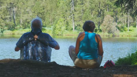 Una-Pareja-Mayor-Disfruta-De-Su-Tiempo-Juntos-Conversando,-Compartiendo-Algo-De-Comida-Y-Disfrutando-De-La-Naturaleza-Que-Los-Rodea