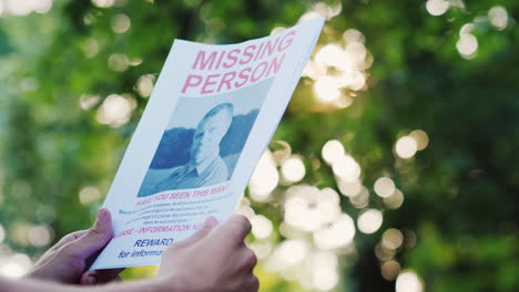 man holding a flyer with the announcement of the missing man