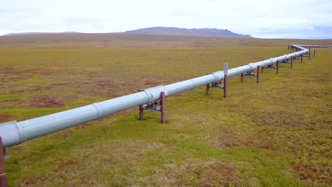 Aerial-view-following-the-crude-oil-pipeline,-at-the-Dalton-Highway,-cloudy,-fall-day,-in-Alaska,-USA---reverse,-drone-shot