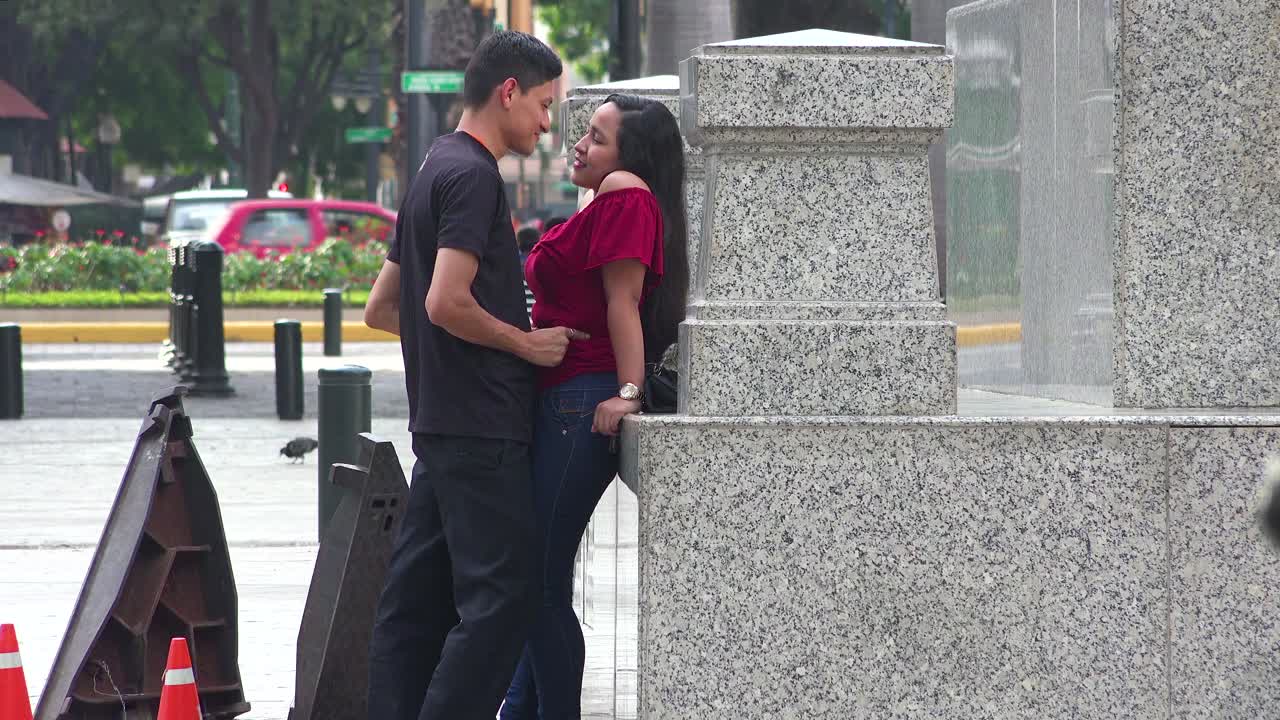 에콰도르 과야킬 거리에서 한 남자가 젊은 여성의 키스를 훔치려 한다