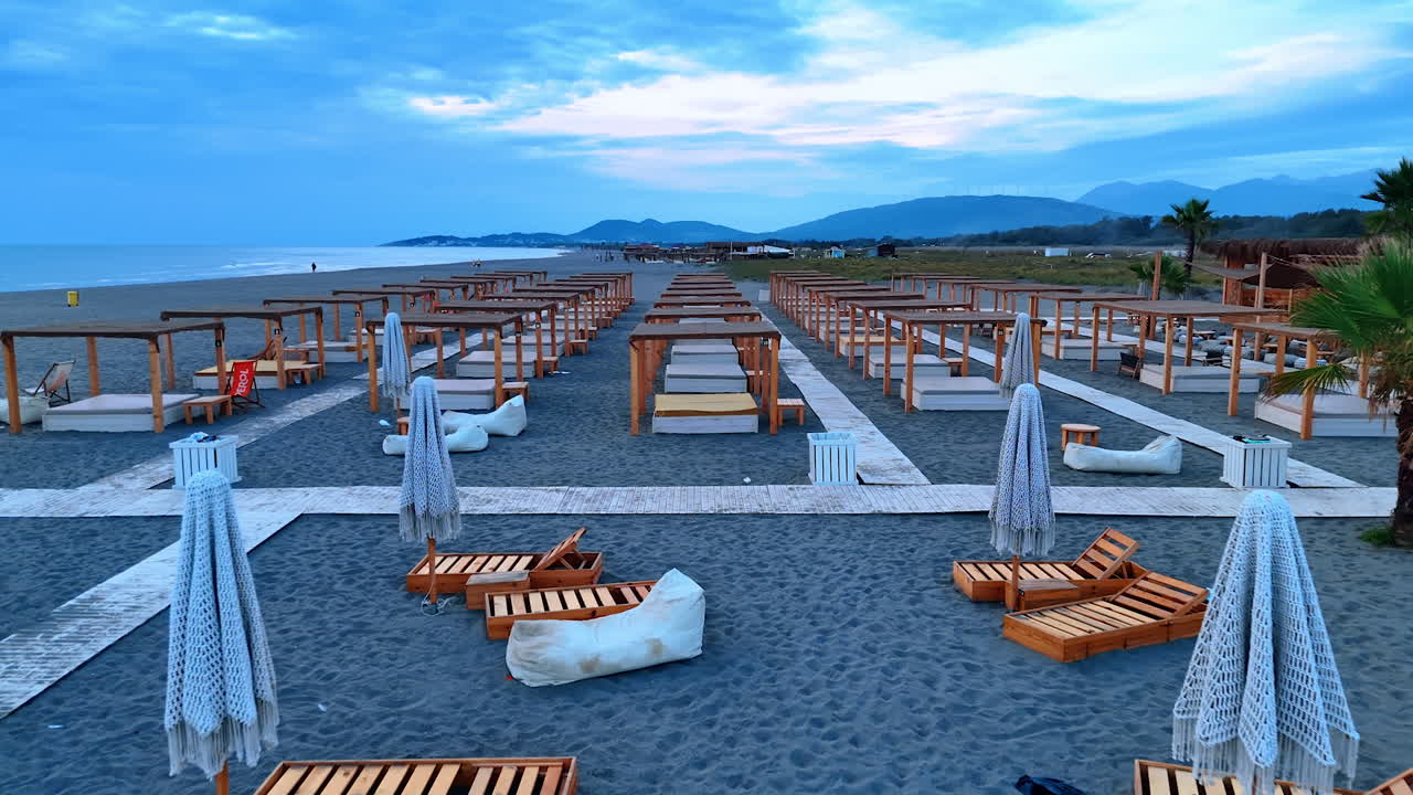 Ulcinj, Montenegro, 14 August 2025: Empty Beach Morning View. Wide quiet Montenegro beach with empty loungers under soft morning sky