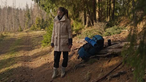 una mujer caminando en el bosque con una mochila