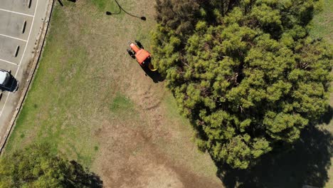 Toma-Aérea-De-Arriba-Hacia-Abajo-Del-Tractor-Arando-Semillas-En-El-Campo-Del-Parque-Durante-El-Día-Soleado-En-El-Oeste-De-Australia