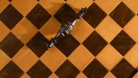 black king and queen from chess set, laying down together like defeat from a war