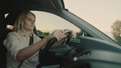 Middle-aged-female-driver-drives-car-in-setting-sun-6