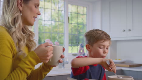 Madre-E-Hijo-En-Casa-Comiendo-Cereales-Para-El-Desayuno-Juntos-En-La-Encimera-De-La-Cocina