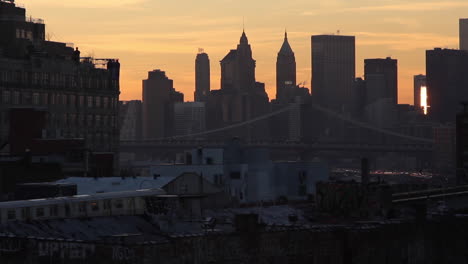 sunrise subway train moves into brooklyn from the city, across the bridge, skyline buildings-2