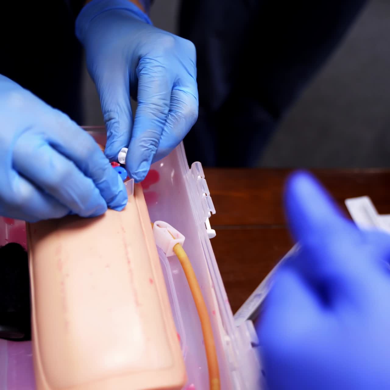 Putting the medical catheter. Learning a catheter installation on a dummy hand. Medical skills training. Close-up.