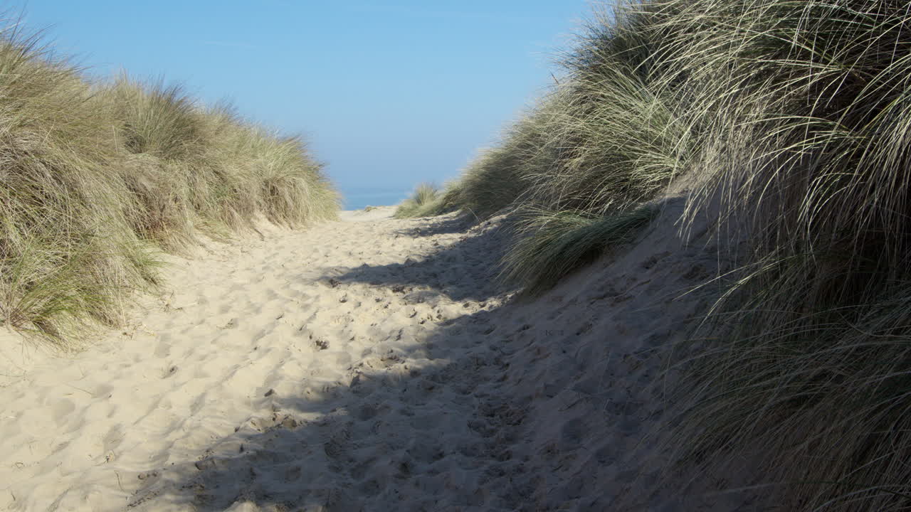 wide shot looking up eroded path through sand dunes at Horsey beach next to Winterton on Sea,