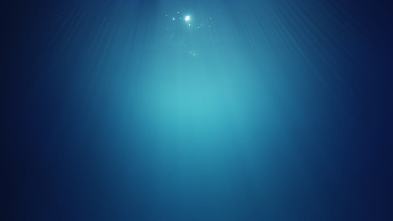 Underwater sunlight beams shining from above coming through the deep crystal clear blue water causing a beautiful water lighting reflections curtain