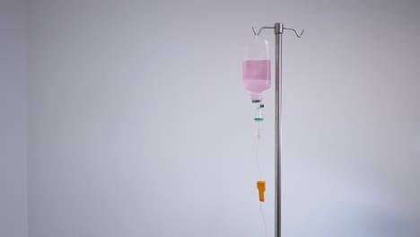 iv drip bag on stand with pink liquid
