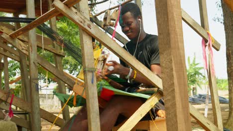 african male artisan from ghana weaving kente traditional woven