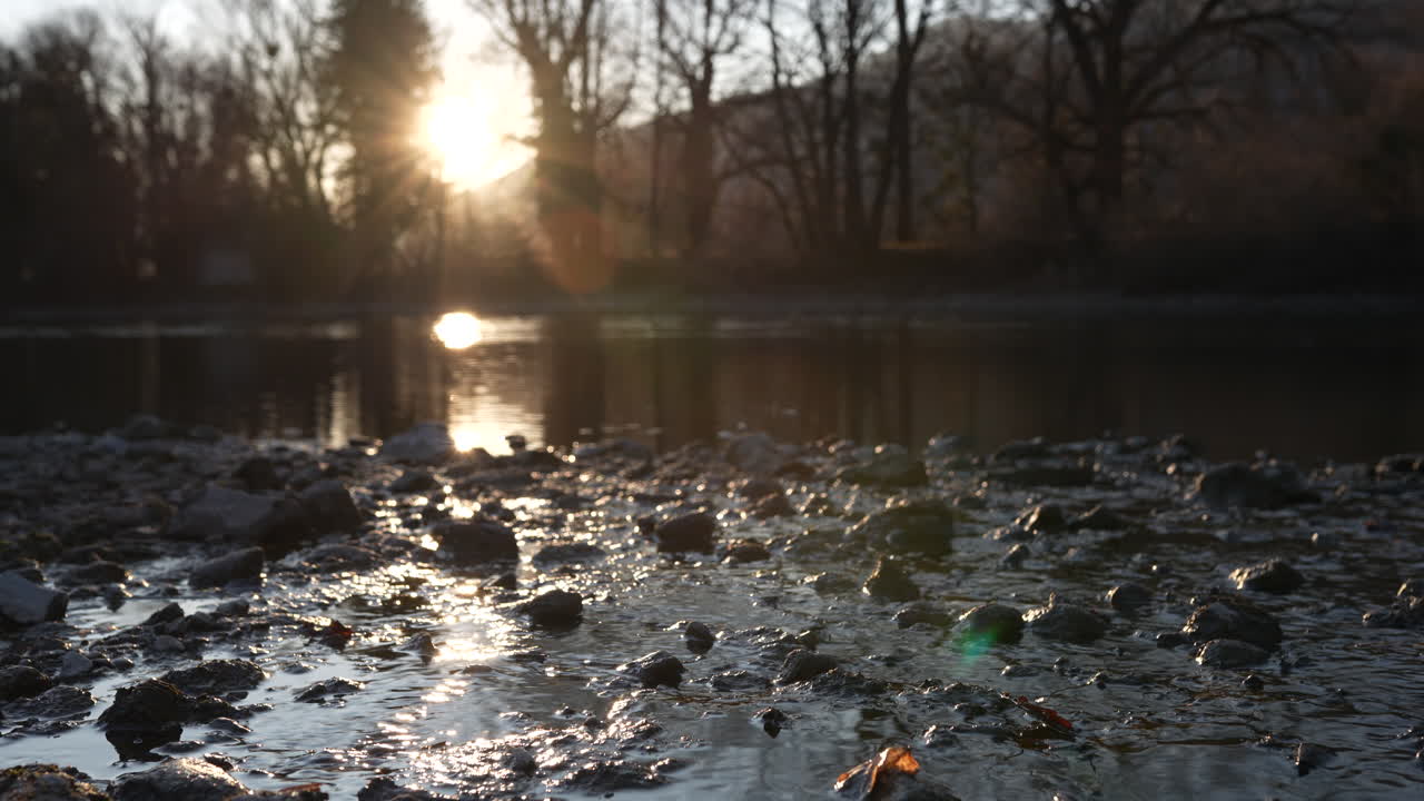 Serene view of the Walensee lake shoreline with morning sun over the water
