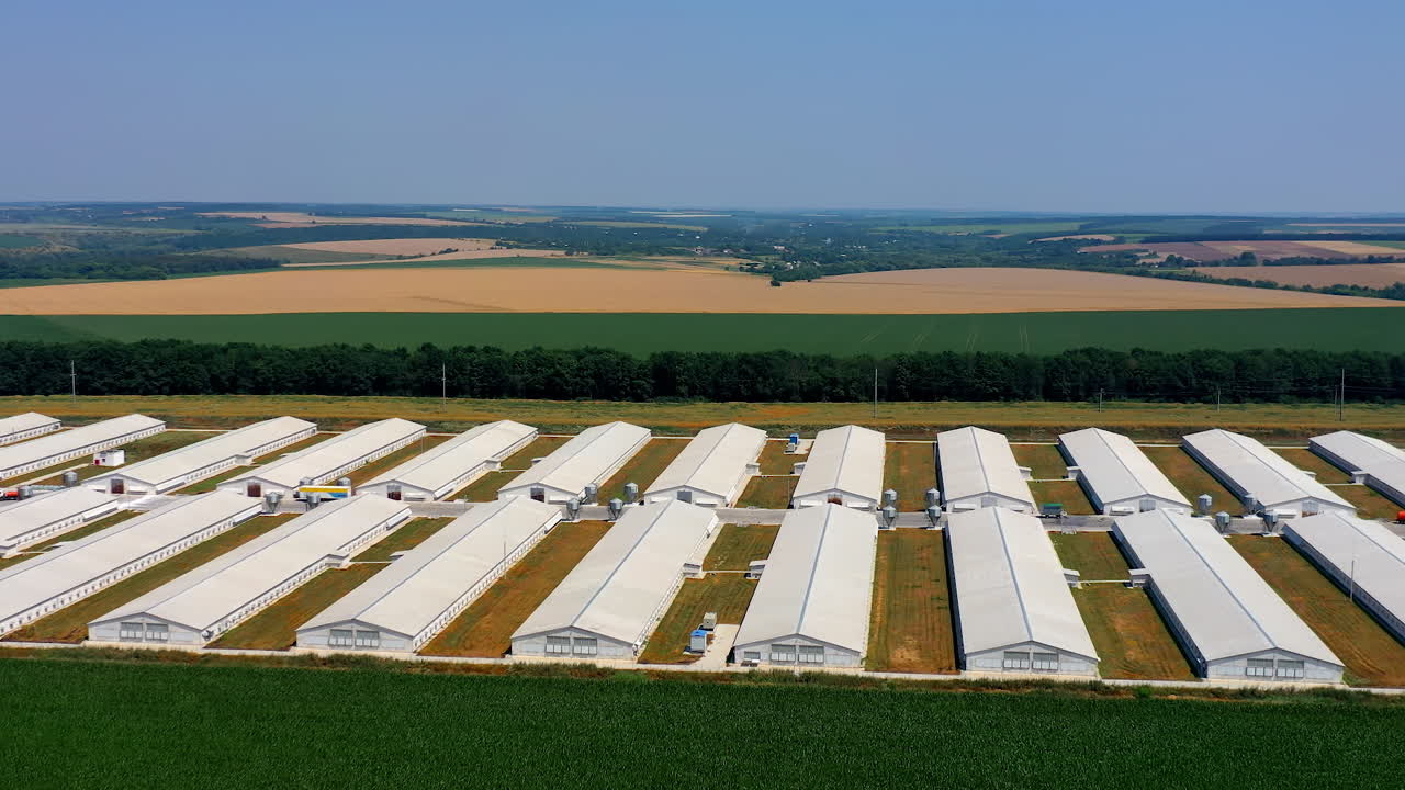 Aerial view of agricultural buildings on the field. Huge territory of manufacturing in nature.