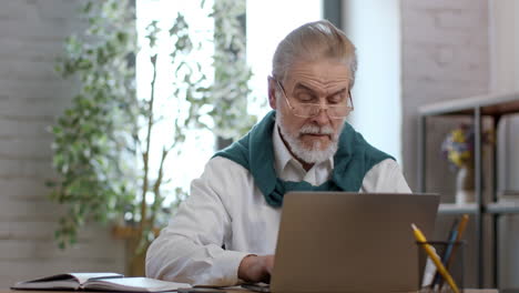 older man working on laptop