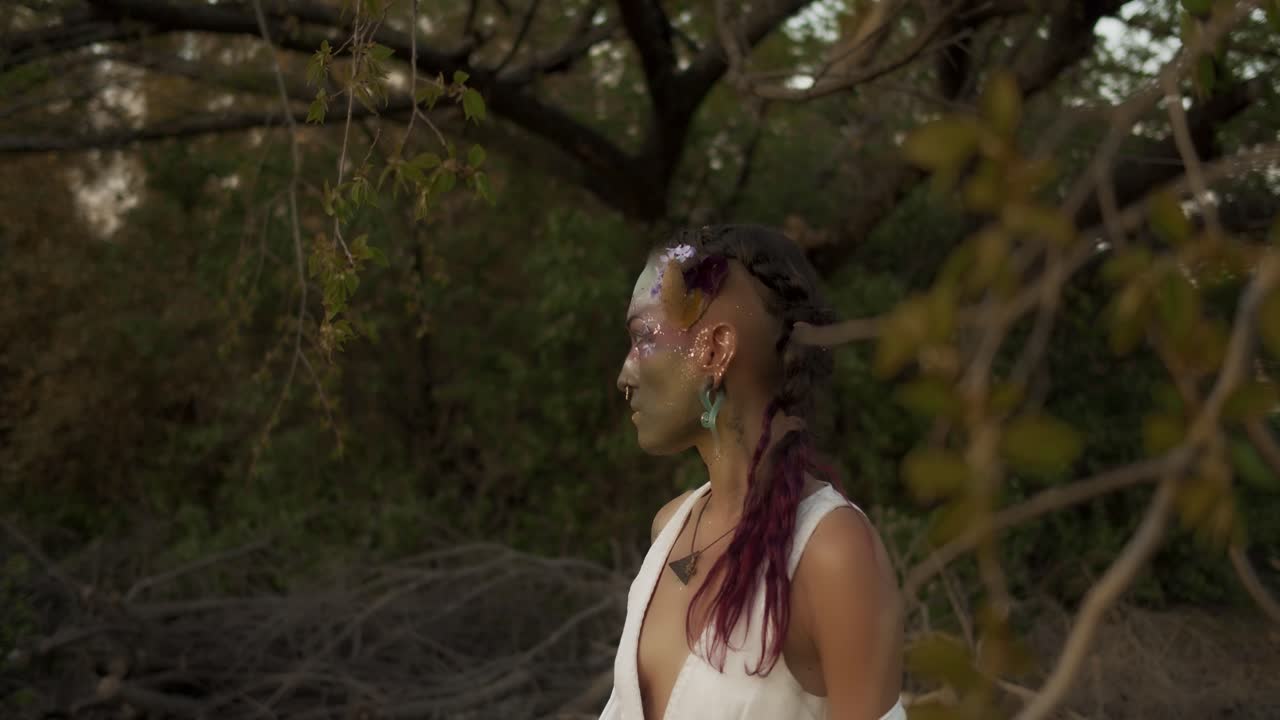 vista a media distancia de una mujer con el rostro pintado y parte corta de su ritual de cuento para las vacaciones escocesas beltane